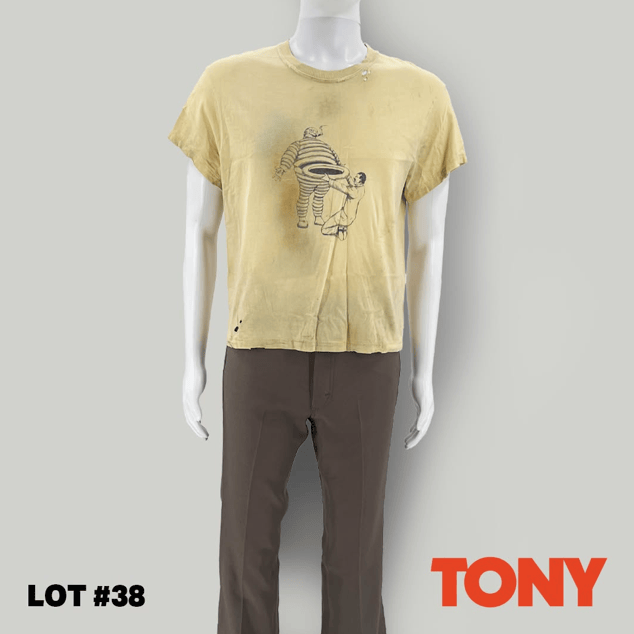 A mannequin wearing a yellow vintage t-shirt featuring a graphic print and brown pants, displayed against a neutral background.