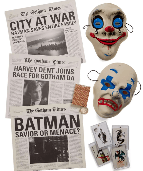 A collection of newspapers titled 'The Gotham Times' featuring headlines about Batman, a clown mask, a deck of cards, and a large joker mask, depicting themes related to Gotham City.